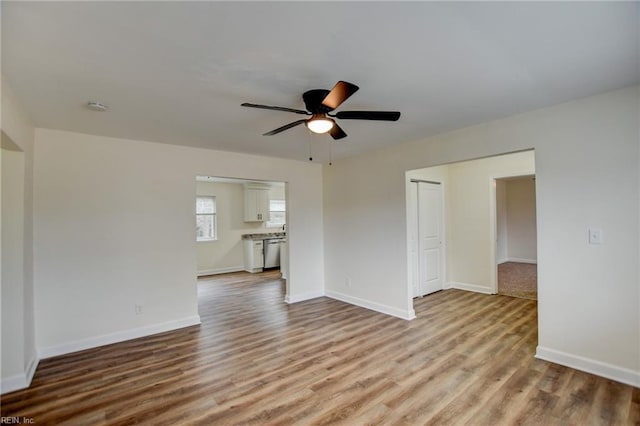 spare room with ceiling fan, baseboards, and wood finished floors