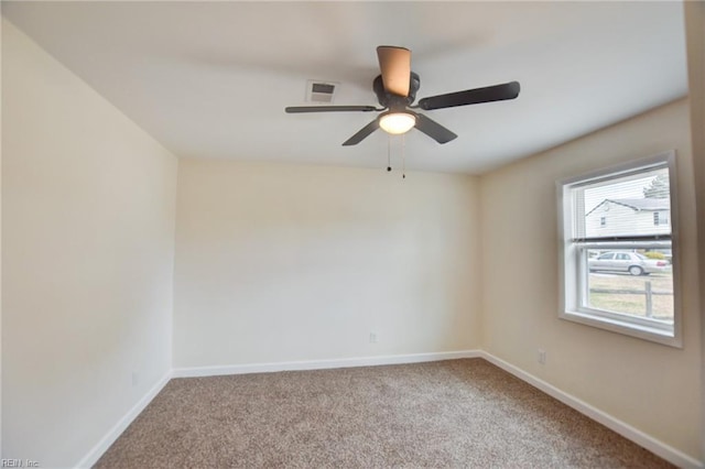 spare room featuring carpet, visible vents, and baseboards