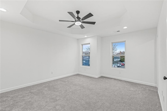 unfurnished room with carpet floors, recessed lighting, a raised ceiling, and baseboards