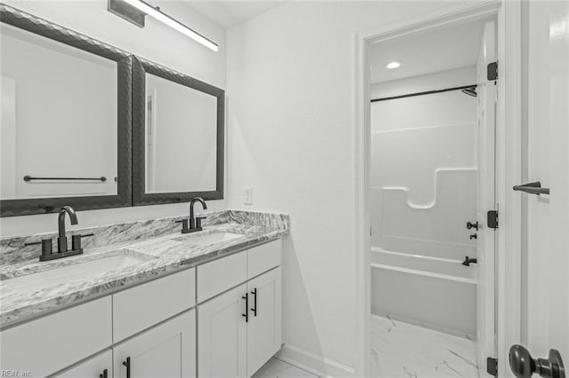 full bathroom featuring marble finish floor, double vanity, a sink, and shower / tub combination