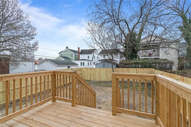 wooden terrace with a fenced backyard