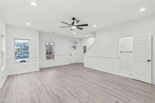 unfurnished living room featuring light wood-style floors, wainscoting, and recessed lighting