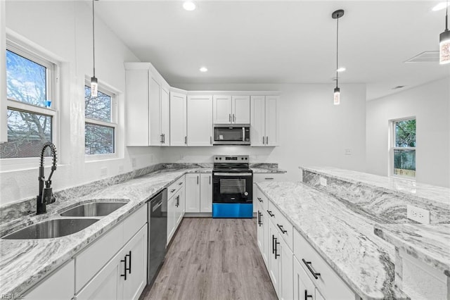 kitchen with recessed lighting, a sink, white cabinets, appliances with stainless steel finishes, and light wood finished floors