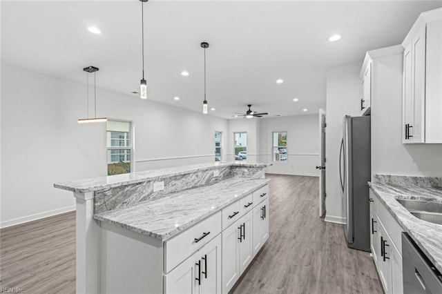 kitchen featuring recessed lighting, stainless steel appliances, a kitchen island, white cabinets, and light wood finished floors