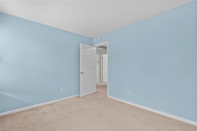 unfurnished room featuring baseboards and light colored carpet