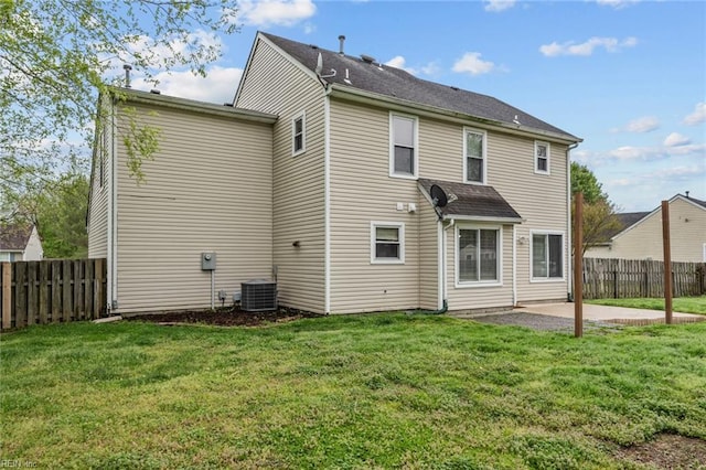 rear view of house featuring a fenced backyard, cooling unit, a lawn, and a patio