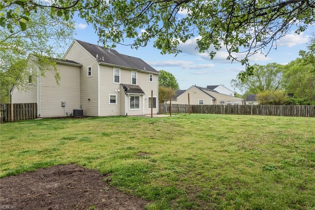 rear view of property featuring a lawn, a fenced backyard, and central air condition unit