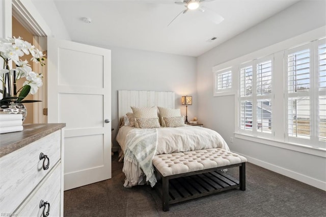 bedroom featuring baseboards, visible vents, dark carpet, and a ceiling fan