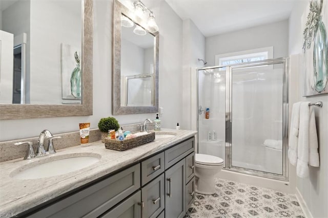 full bath featuring a stall shower, a sink, and toilet