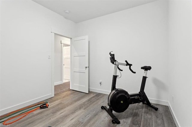 workout room featuring wood finished floors and baseboards