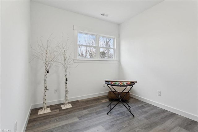 misc room with baseboards, visible vents, and wood finished floors