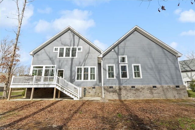 rear view of property with a deck, crawl space, and stairway