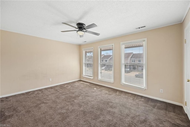 carpeted spare room featuring a ceiling fan, visible vents, a textured ceiling, and baseboards