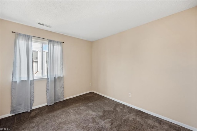 carpeted empty room with a textured ceiling, visible vents, and baseboards