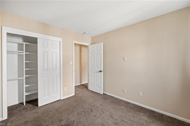 unfurnished bedroom with carpet, a textured ceiling, baseboards, and a closet