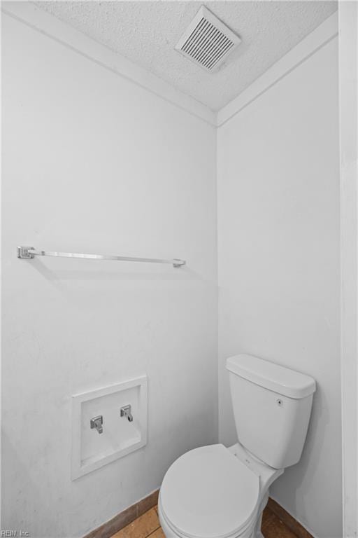 bathroom featuring visible vents, a textured ceiling, and toilet