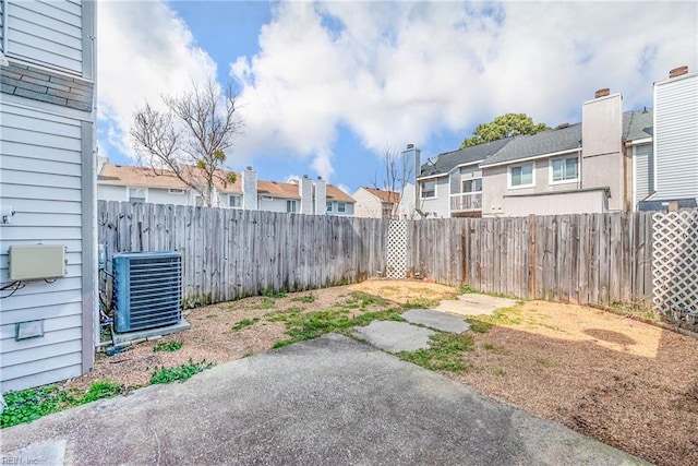 view of yard with a fenced backyard, cooling unit, and a residential view