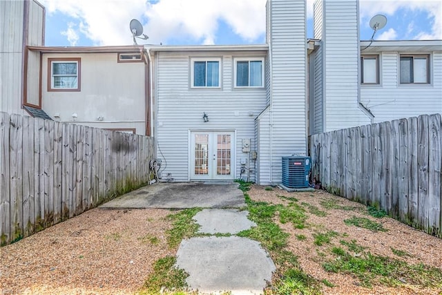 rear view of property featuring a patio, french doors, cooling unit, and a fenced backyard