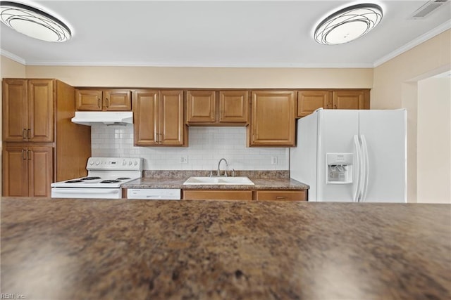 kitchen featuring white appliances, brown cabinets, a sink, and under cabinet range hood