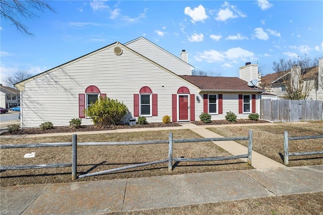 view of front of home with a fenced front yard and a chimney