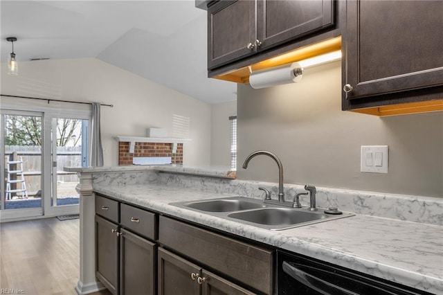 kitchen with dark brown cabinetry, black dishwasher, vaulted ceiling, light countertops, and a sink