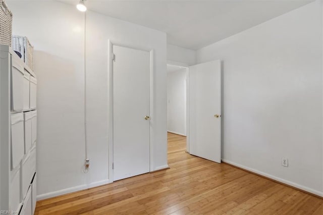 unfurnished bedroom with baseboards and light wood-style flooring