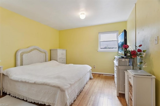 bedroom with light wood-type flooring and baseboards