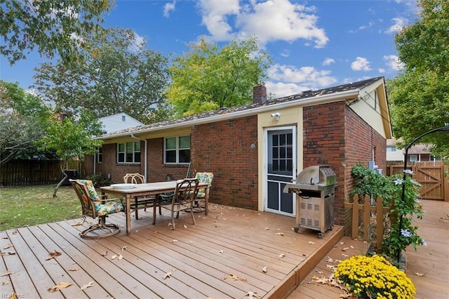 wooden terrace featuring area for grilling, outdoor dining space, and fence