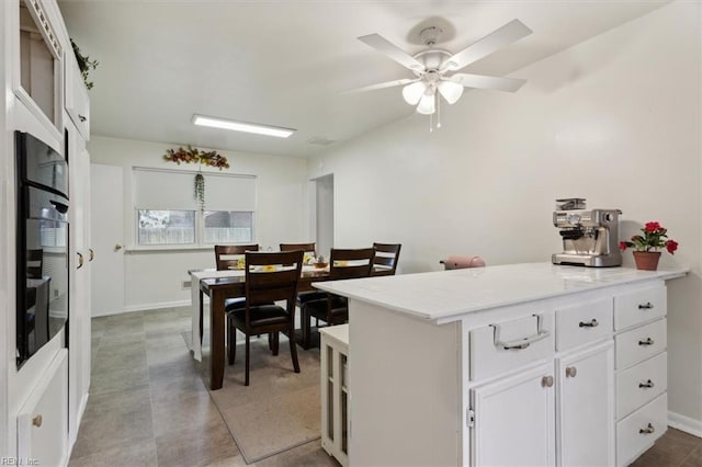 kitchen featuring a peninsula, white cabinets, and a ceiling fan