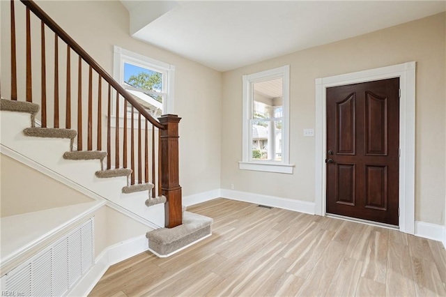 entrance foyer featuring light wood finished floors, plenty of natural light, visible vents, and baseboards