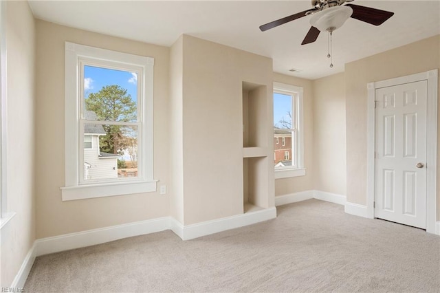 unfurnished bedroom featuring multiple windows, carpet, and baseboards