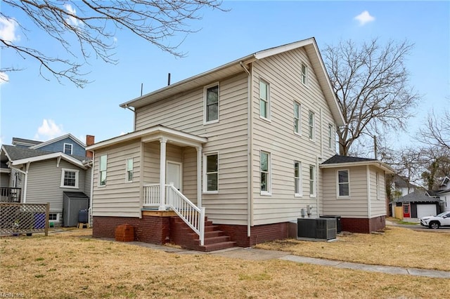 view of front of house featuring a front lawn and cooling unit