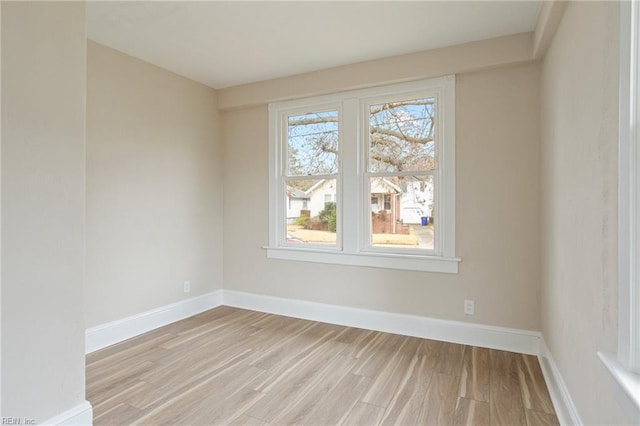 spare room featuring light wood-style flooring and baseboards