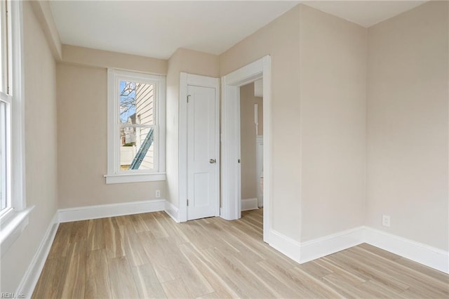 unfurnished room featuring light wood-style flooring and baseboards