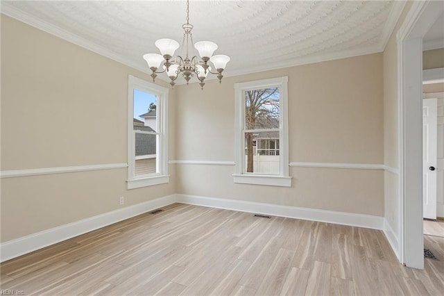 unfurnished dining area featuring baseboards, crown molding, an inviting chandelier, and light wood-style floors