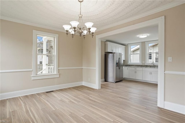 kitchen with white cabinetry, plenty of natural light, stainless steel refrigerator with ice dispenser, and light wood finished floors