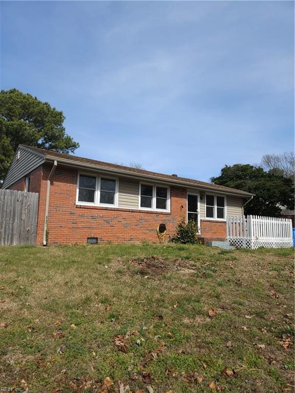 single story home featuring brick siding, a front yard, and fence