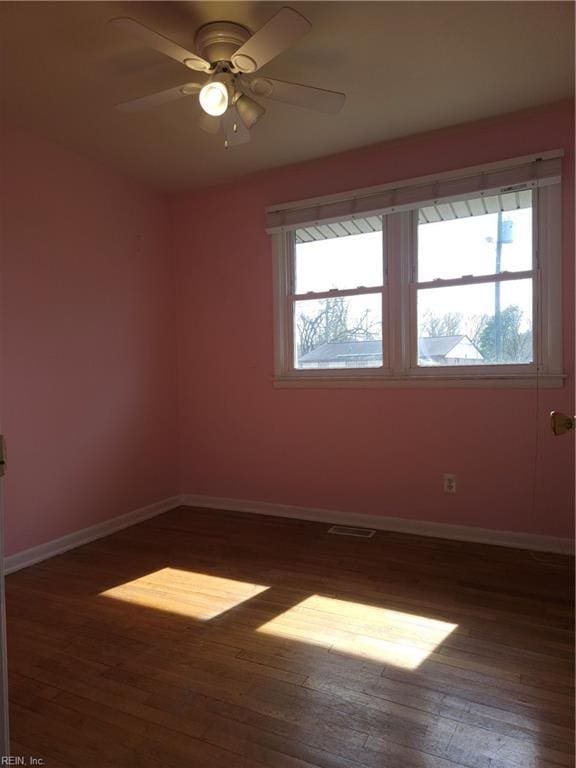 empty room featuring visible vents, ceiling fan, baseboards, and wood finished floors