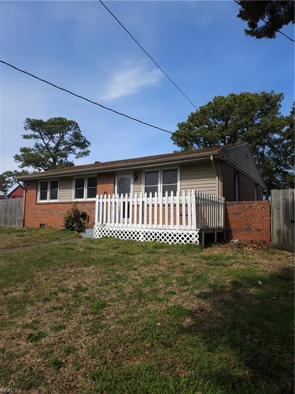 view of front of house with brick siding, crawl space, and fence