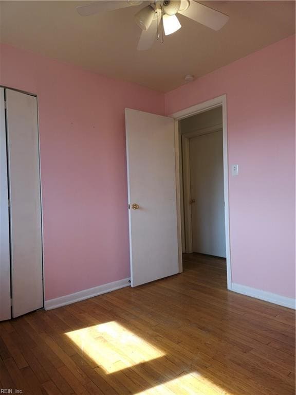 unfurnished bedroom featuring light wood-style floors, baseboards, and a ceiling fan