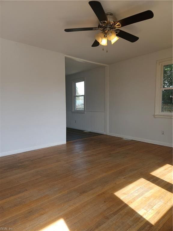 empty room featuring ceiling fan, hardwood / wood-style floors, and baseboards