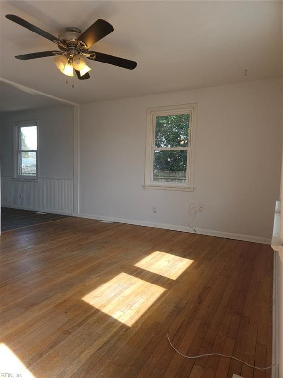 unfurnished room featuring ceiling fan, hardwood / wood-style floors, and baseboards