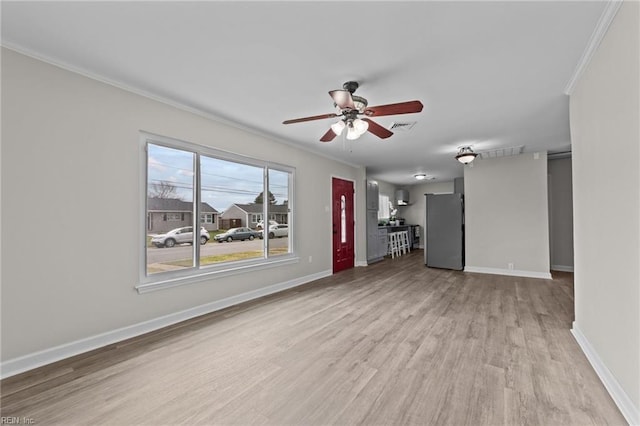 unfurnished living room featuring crown molding, visible vents, light wood-style floors, ceiling fan, and baseboards