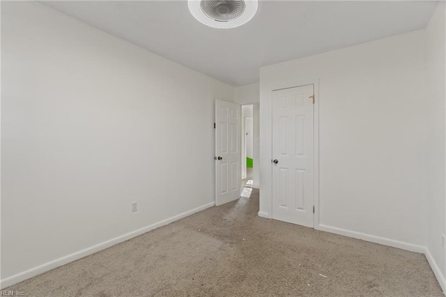 spare room featuring carpet flooring and baseboards