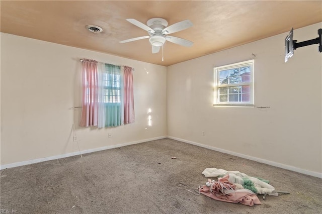 carpeted spare room with visible vents, ceiling fan, and baseboards