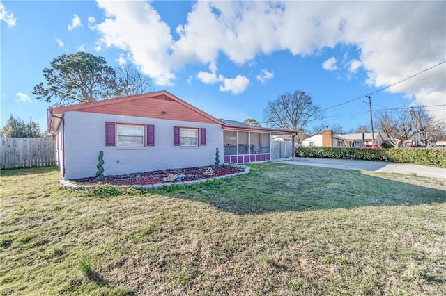 ranch-style home with a sunroom, brick siding, a front lawn, and fence