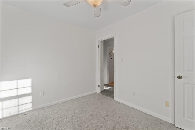 empty room featuring baseboards, carpet floors, and ceiling fan