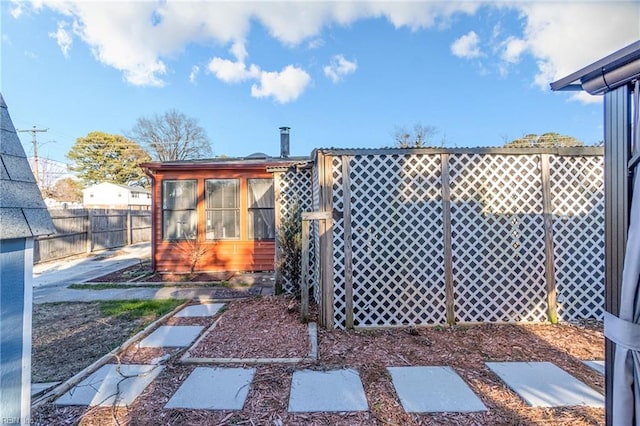 view of yard with a fenced backyard and a sunroom