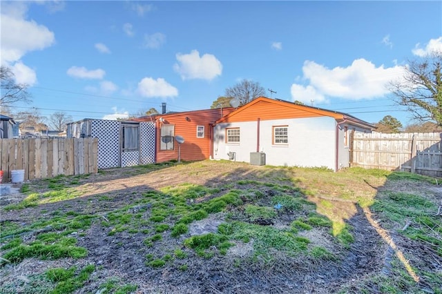 rear view of property with central AC and fence