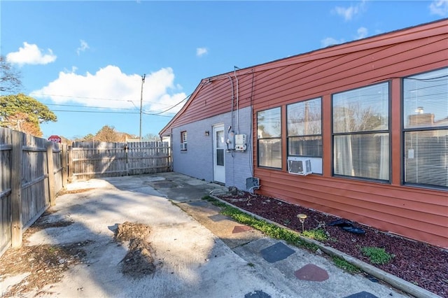 view of side of property featuring cooling unit, a patio, and a fenced backyard